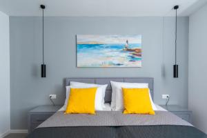 a bedroom with a bed with two yellow pillows at Villa Lotta by Istrialux in Labin