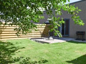 a yard with a table and a chair in front of a building at Beckside House in Dalton in Furness