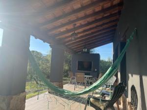 Eine Hängematte auf einer Terrasse mit Fernseher und Stühlen in der Unterkunft Casa en La Comarca in San Javier