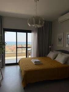 a bedroom with a large bed and a large window at Caesar Blue Resort Spa Sea view apartment H-49 in Vrysoules