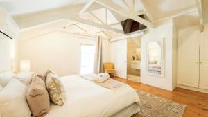 een slaapkamer met een groot wit bed in een kamer bij Waymaker Cottage in Franschhoek +32 foto's
