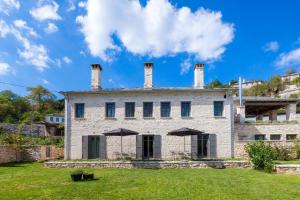 an old stone house with two chimneys at Apeiros Chora Hotel in Kato Pedina