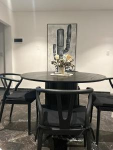 a black table and chairs with a picture on the wall at Departamento Avenida España in Mendoza +12 photos