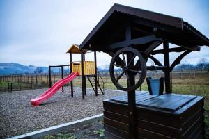 a playground with a red slide and a play structure at FLH - Trofeul Cerbului in Negrileşti
