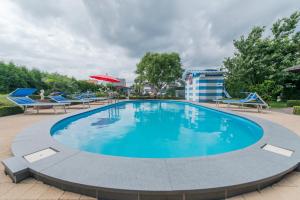 宗奥芬B&B Casa Roman & Vakantiewoning voor 1 pers tot max 32 personen的度假村内一个蓝色的大泳池