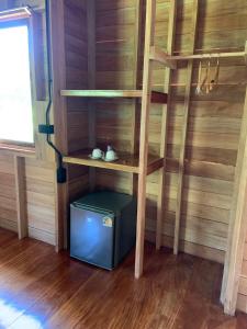a wooden shelf in a room with a small refrigerator at Koh Mook Banana Garden in Ko Libong