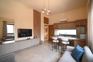 a kitchen with a couch and a bar with stools at Sands Guesthouse Apartment 03 In Batroun in Batroûn +9 photos
