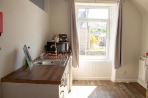 a kitchen with a sink and a window at Poseidon's in Lossiemouth