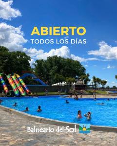 an outdoor swimming pool with people in the water at Cabañas "Lola Mora" in Tandil