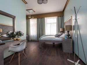 a bedroom with a bed and a desk and a mirror at Gorgeous Prague Rooms in Prague