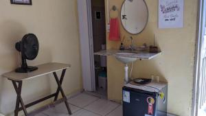 a bathroom with a sink and a mirror on the wall at Kitinete e suite Recanto do Bem-te-vi in Serra