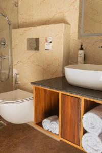 a bathroom with a sink and a tub and a toilet at asar Capoors Hotel by Orion Hotels in Lucknow +28 photos