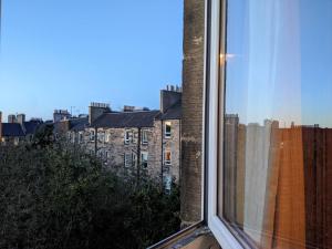 a window with a view of a building at Cosy 1 bedroom flat close to city centre in Edinburgh