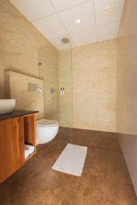 a bathroom with a toilet and a glass shower at asar Capoors Hotel by Orion Hotels in Lucknow