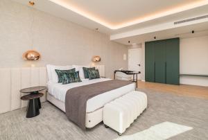 a bedroom with a large white bed and a green door at Haven Nature Hotel & Villas in Batalha