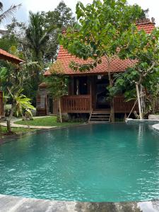 a house with a swimming pool in front of a house at Green vanilla Suite 2 in Silebeng