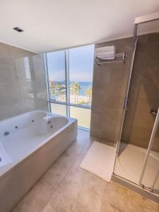 منتجع عافية وسبا إليكا هوتيل في تشيشمي: حمام كبير مزود بحوض استحمام ودش وإطلالة على المحيط