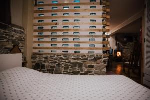 a bedroom with a stone wall with a bed at Handmade semi basement in Ioannina