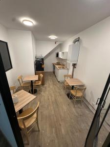 a room with tables and chairs and a kitchen at Suite 1- La Petite Auberge in Langres