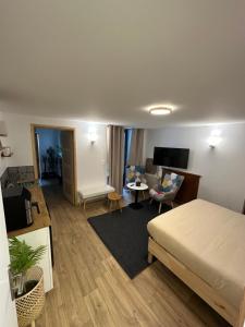 a bedroom with a bed and a living room at Suite 1- La Petite Auberge in Langres