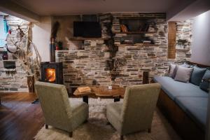 a living room with a table and a stone wall at Handmade semi basement in Ioannina