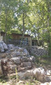 ein Haus mit einer Steinmauer und Bäumen und einem Gebäude in der Unterkunft Les Gites De Chauzon 3 Avec Piscine in Chauzon