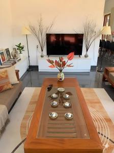 a coffee table in a living room with a tv at Pin's House - Nhà Nghỉ Dưỡng Nguyên Căn 4 phòng ngủ 4 WC Đầy Đủ Tiện Nghi in Bảo Lộc