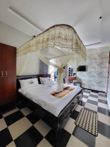 a bedroom with a canopy bed with a checkered floor at Tigris Residence in Bulenga