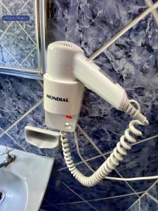 a white phone on a wall next to a sink at Hotel Benfica in Aparecida