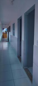 un couloir d'un immeuble de bureaux avec des portes en verre dans l'établissement Pousada Rio Mar, à Maxaranguape