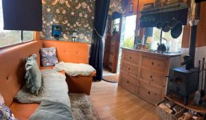 a living room with an orange couch and a stove at Flowerdew Farm in Puncknowle