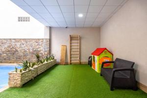 ein Zimmer mit einem Spielzimmer mit einem Haus und Rasen in der Unterkunft Casa Arne in Torrevieja