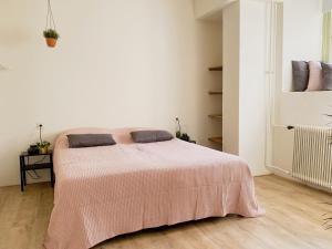 een slaapkamer met een bed met een roze deken bij Modern Apartment 2 in Historic Abbey in Bemelen