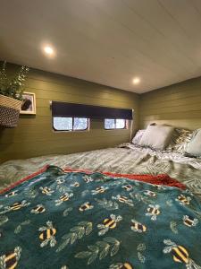 a bedroom with a bed with a blanket on it at Flowerdew Farm in Puncknowle
