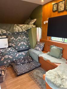 a room with couches and pillows in a tiny house at Flowerdew Farm in Puncknowle +16 photos
