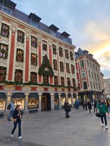 Un gran edificio con un árbol de Navidad delante. en L'Atelier des rêves - Dream apartment for 6, en Lille