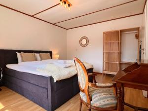 a bedroom with a bed and a desk and a piano at City Center Apartment 1 in Interlaken
