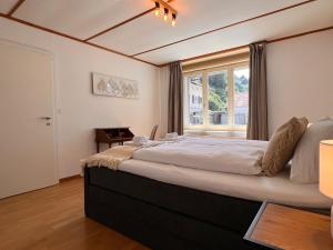 a bedroom with a large bed with a window at City Center Apartment 1 in Interlaken