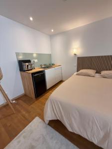a bedroom with a large bed and a kitchen at Suite 2- La Petite Auberge in Langres