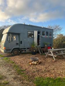 a green trailer parked next to a picnic table at Flowerdew Farm in Puncknowle