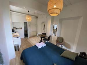 1 Schlafzimmer mit einem blauen Bett und einer Küche in der Unterkunft Modern Studio 3 in Historic Abbey in Bemelen