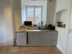 eine Küche mit einer Theke mit Spüle und einem Fenster in der Unterkunft Modern Studio 3 in Historic Abbey in Bemelen