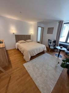 a bedroom with a bed and a table and a chair at Suite 2- La Petite Auberge in Langres
