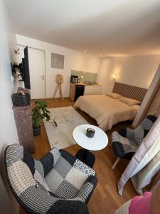 a living room with a bed and a table and chairs at Suite 2- La Petite Auberge in Langres