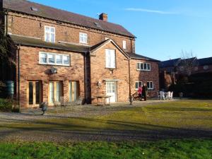 una casa de ladrillo con una mesa delante en Garden flat at Broomfield, en Moffat