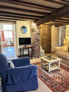 Una sala de estar con un sofá azul y una mesa. en Garden flat at Broomfield, en Moffat