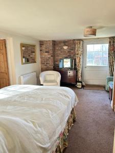 Un dormitorio con una cama y una silla y una ventana. en Garden flat at Broomfield, en Moffat