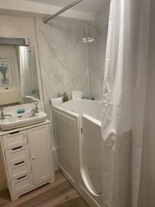 Un baño con bañera blanca y lavabo. en Garden flat at Broomfield, en Moffat