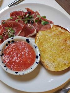 a plate of food with meat and jam and toast at Balcón de Córdoba in Córdoba