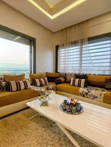 a living room with a couch and a table at 3BR Near Airport Secure,Equipped stay and transit in Nouaseur